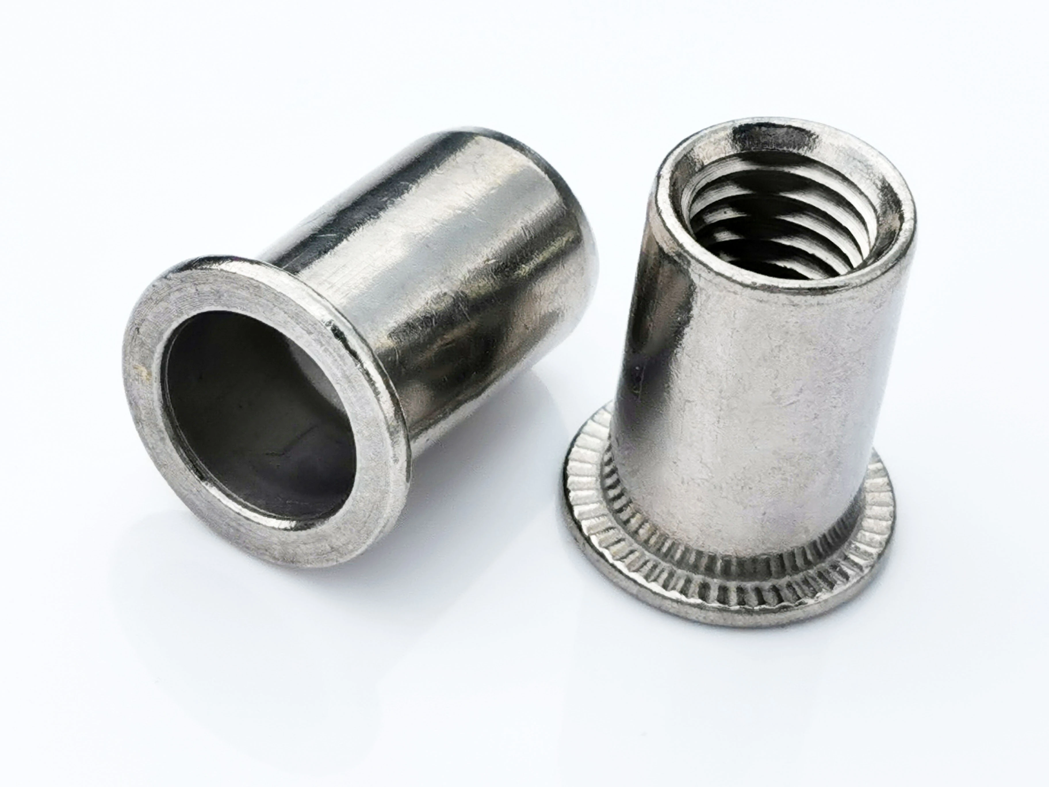 Tuerca remachable ciega de acero inoxidable, cabeza plana, extremo abierto, cuerpo cil&iacute;ndrico liso, serrado radial bajo la brida