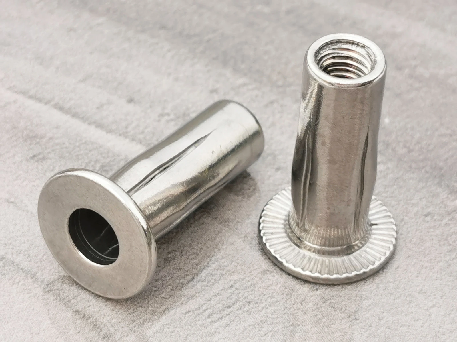 Tuerca remachable ciega de acero inoxidable, cabeza plana, extremo abierto, cuerpo ranurado, serrado radial bajo la brida