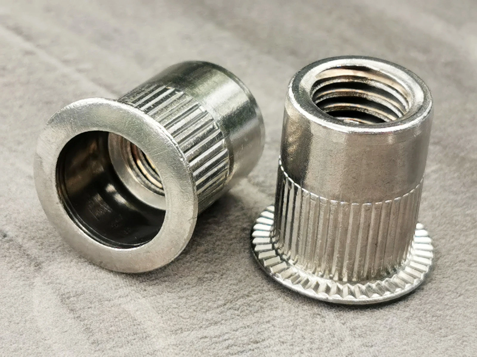 Tuerca remachable ciega de acero inoxidable, cabeza plana, extremo abierto, cuerpo cil&iacute;ndrico moleteado, rosca en pulgadas pendiente de verificaci&oacute;n